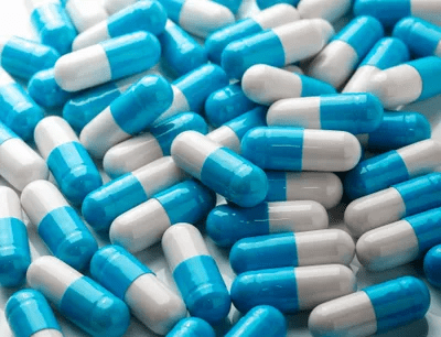 Blue Pills Scattered on a Flat Surface