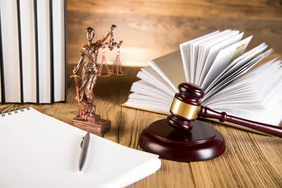 Lady Justice, Gavel, Open Book and a Pen on Table